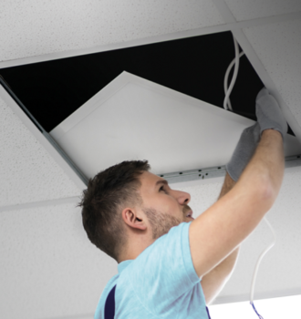 Man fitting led panel in ceiling