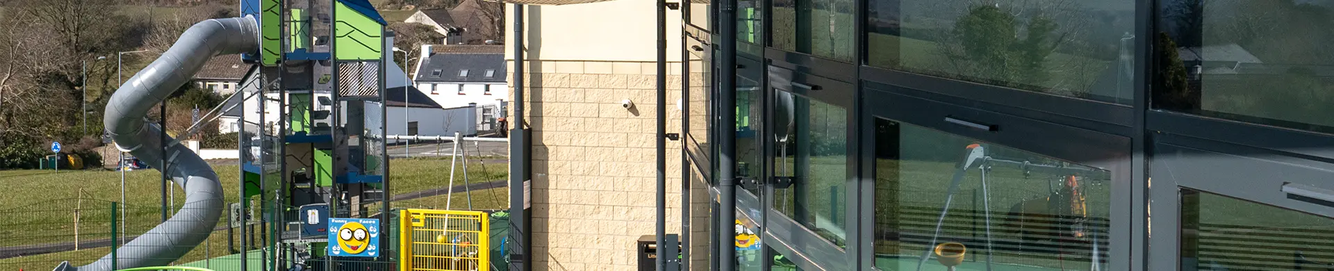 Braddan Communities Header Modern building next to park with a slide