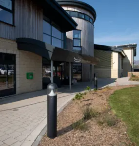 Braddan Communities building with blue sky and bollard